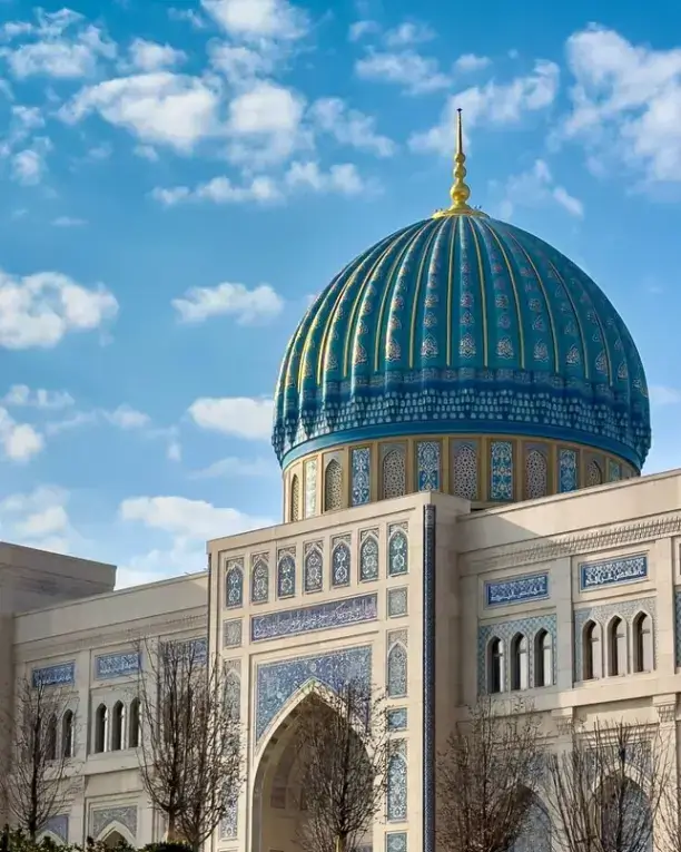 Koshin bilan bezatilgan moviy gumbazli masjid va uning peshtog'i